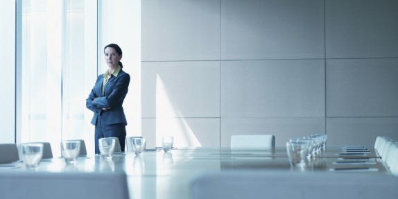 Businesswoman standing alone in conference room